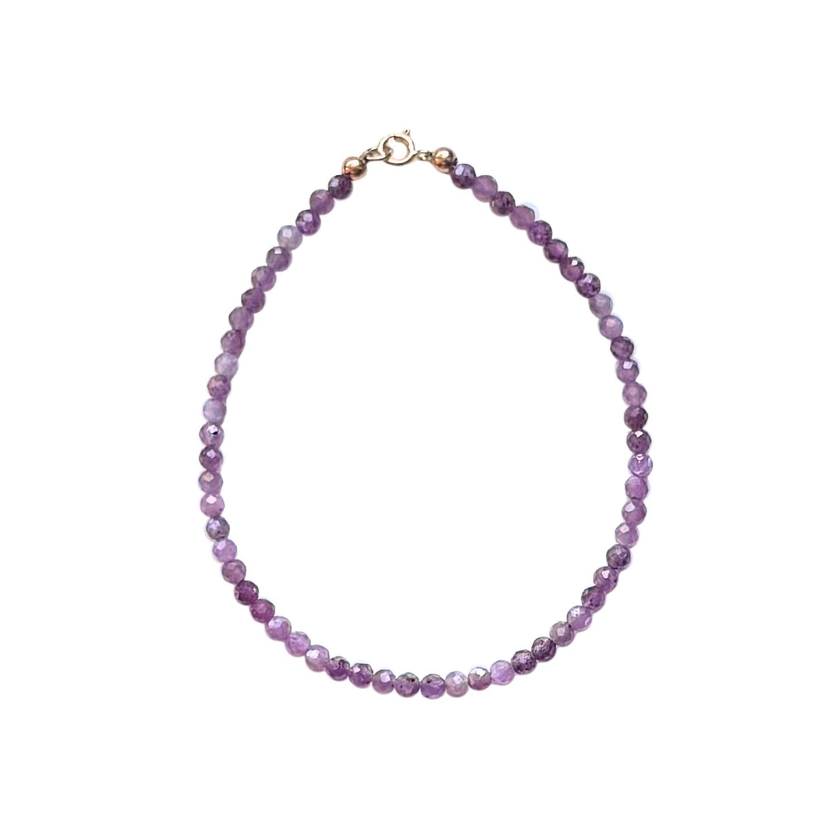 pink ruby bead bracelet with gold hardware on a white background