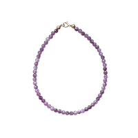 pink ruby bead bracelet with gold hardware on a white background
