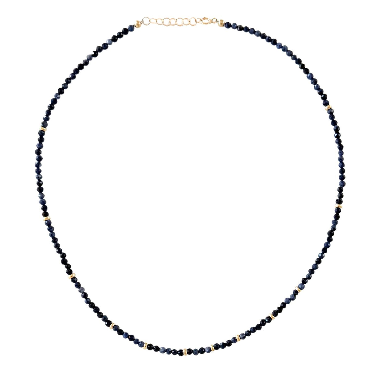 Necklace with dark blue sapphire beads on a white background