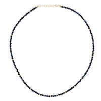Necklace with dark blue sapphire beads on a white background