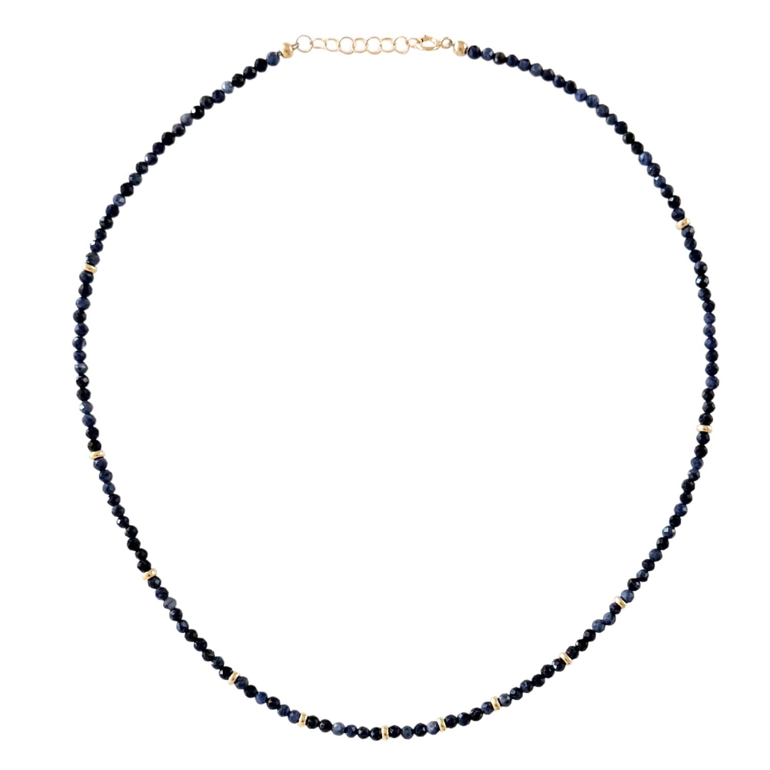 Necklace with dark blue sapphire beads on a white background