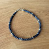 Blue sapphire beaded bracelet on a wooden surface