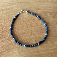 Blue sapphire beaded bracelet on a wooden surface