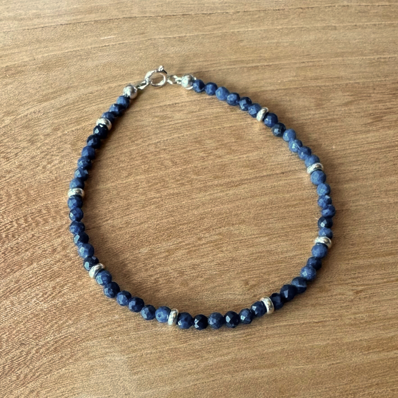 Blue sapphire beaded bracelet on a wooden surface