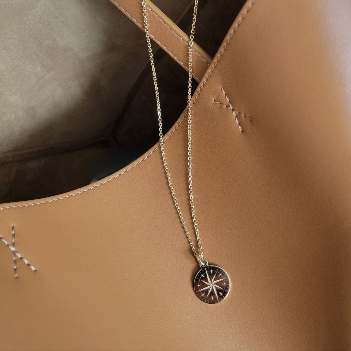 Necklace with a star-shaped pendant on a brown leather surface