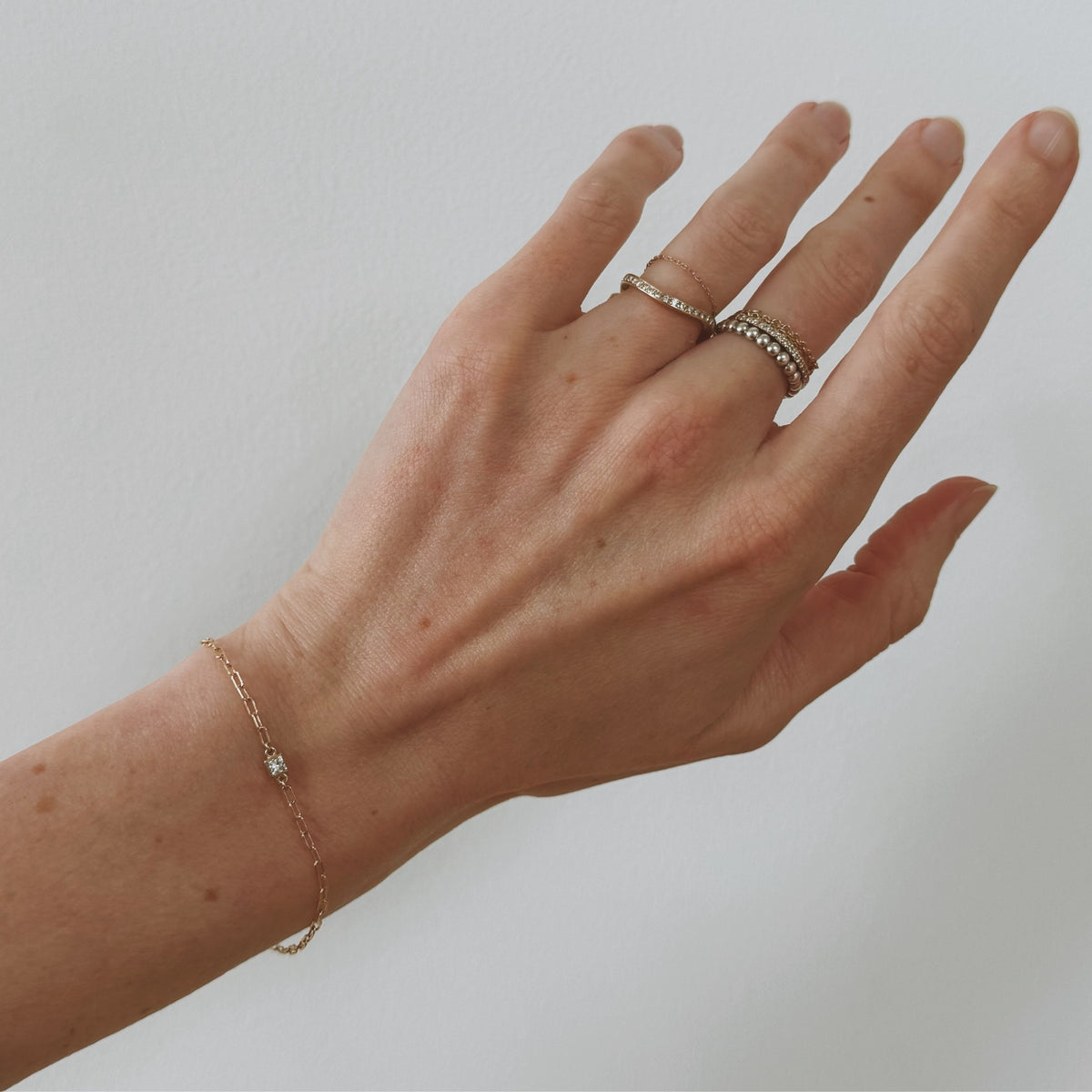 14k gold fairmined paperclip chain bracelet with lab diamond bezel on wrist