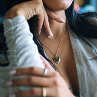 woman wearing a gold heart locket