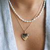 woman wearing a gold heart locket
