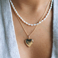 woman wearing a gold heart locket