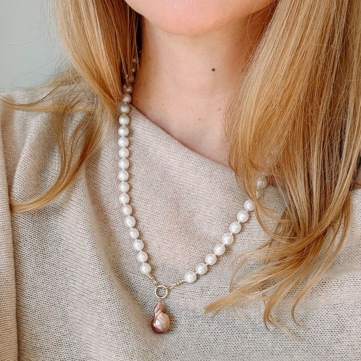 Freshwater Pearl necklace with a baroque pearl pendant worn by a person with blonde hair.