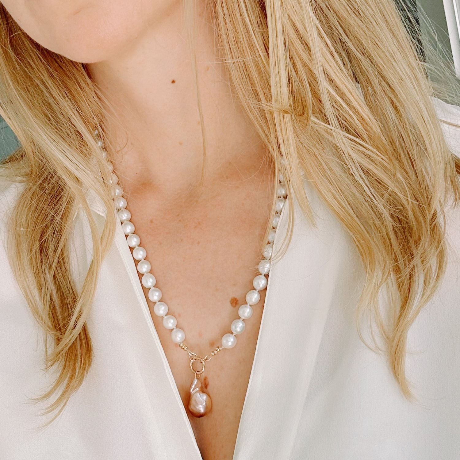 Freshwater Pearl necklace worn by a person with blonde hair, wearing a white top.