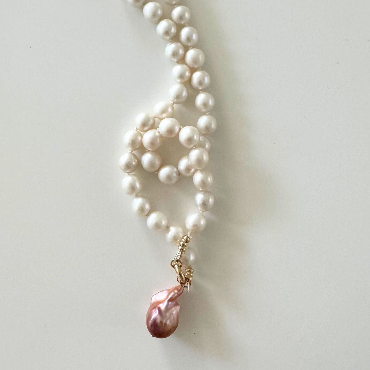 hand-knotted Pearl necklace with a pink pearl pendant on a light background