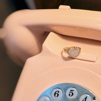 Pink vintage phone with a heart-shaped ring on the receiver