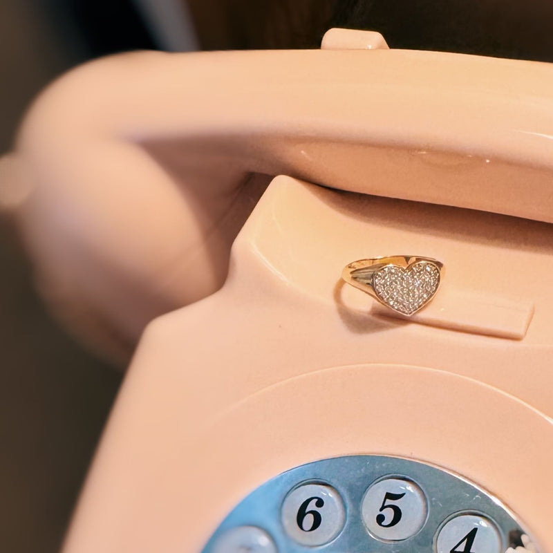 Pink vintage phone with a heart-shaped ring on the receiver