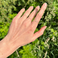 Hand with an eternity diamond ring on a blurred green background