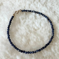 Blue Sapphire and Gold bracelet on shearling.