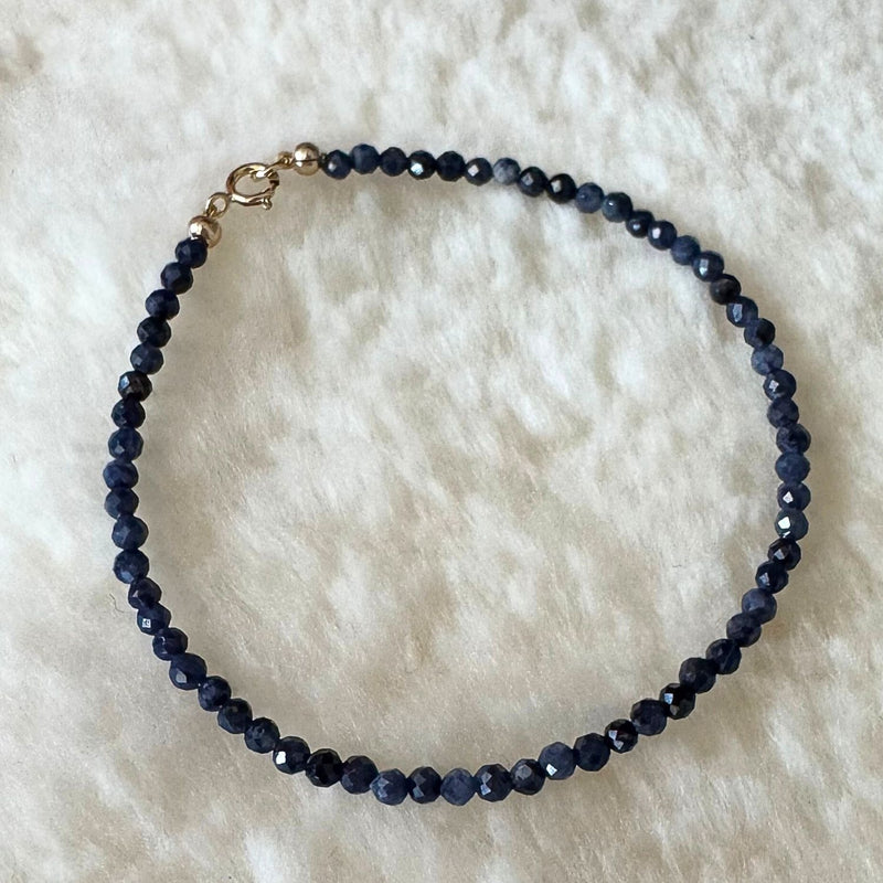 Blue Sapphire and Gold bracelet on shearling.