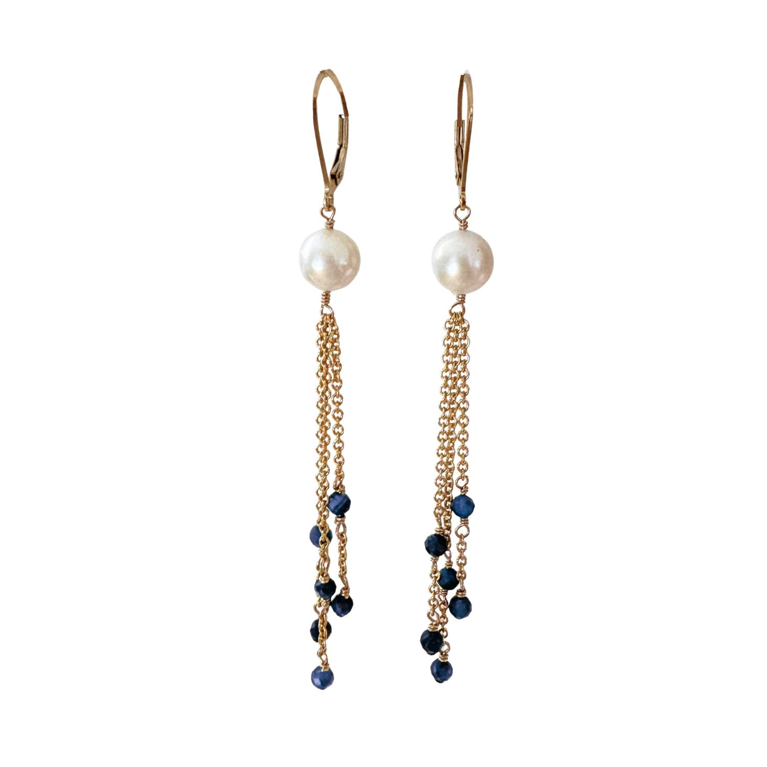 Pair of earrings with pearls and blue sapphire beads on gold chains against a white background