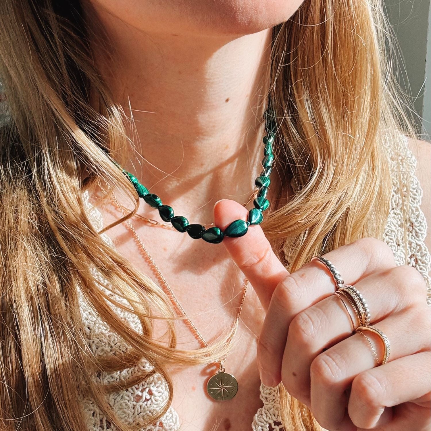Close-up of a person wearing a green malachite beaded necklace.