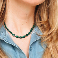 Person wearing a green malachite necklace with a denim shirt