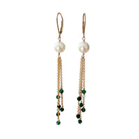 Pair of earrings with pearls and green beads on gold chains against a white background