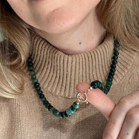 Close up of the toggle clasp on a green bead necklace