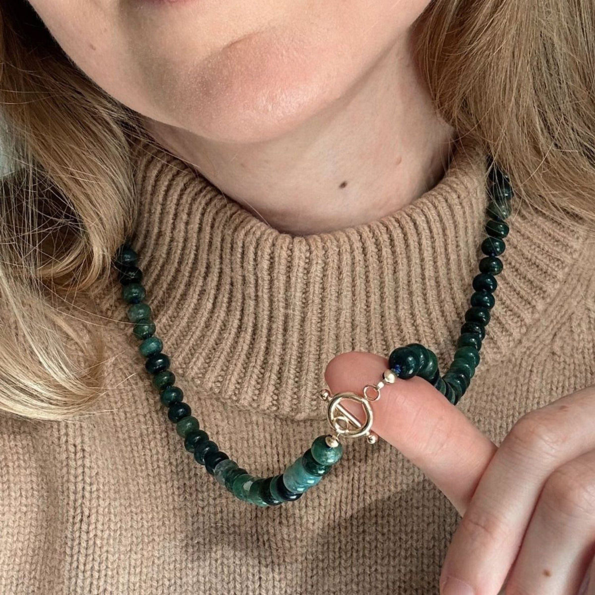 Close up of the toggle clasp on a green bead necklace