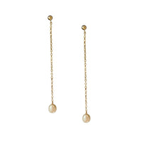 A pair of gold dangle earrings with a small round stud at the top, a delicate chain hanging in the center, and a baroque pearl pendant at the bottom, shown against a plain white background.