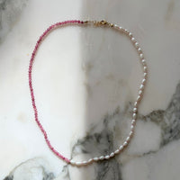 Necklace with pink beads and white pearls on a marble surface