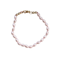 Freshwater pink Pearl bracelet with gold clasp on a white background