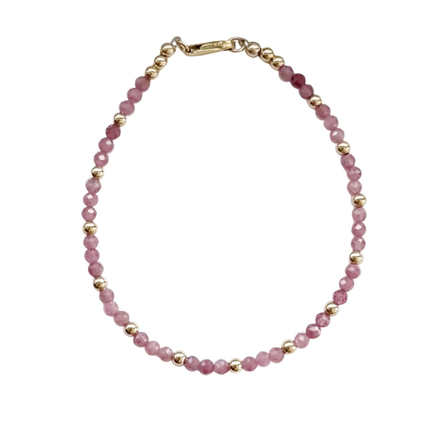 Bracelet with pink beads and gold accents on a white background