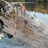 rainbow sapphire necklace on driftwood of autumn lake