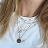 Layered gold necklaces with length measurement labels on a white shirt