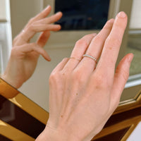 Close-up of hands with a beaded silver ring in front of a mirror