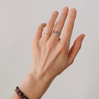 Hand with rings and a bracelet on a plain background