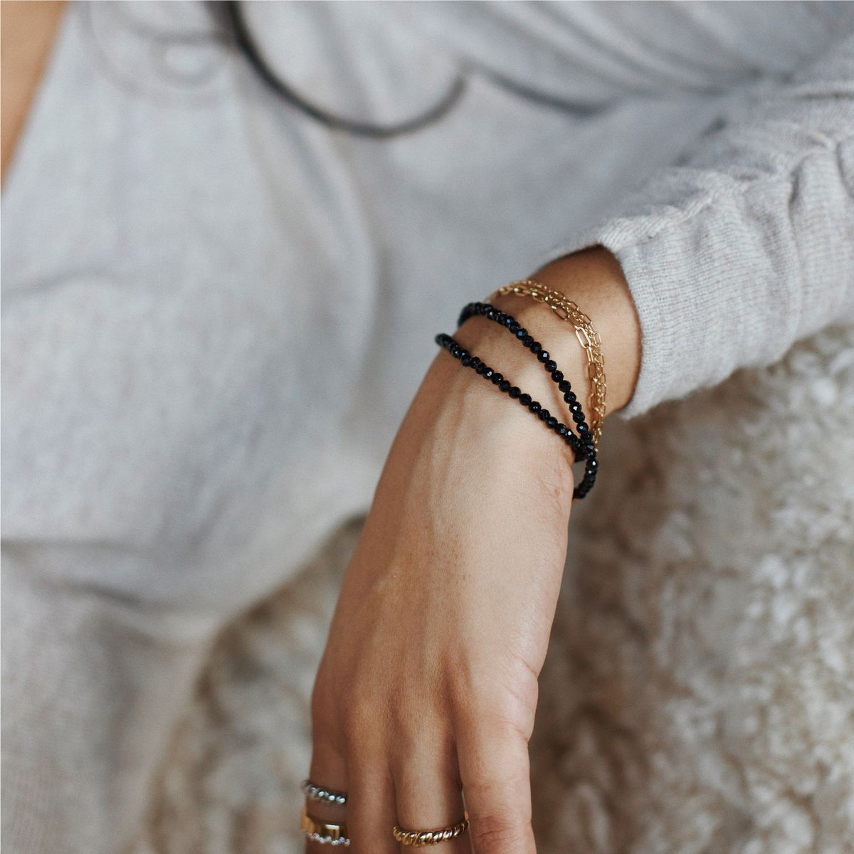 woman wearing stack of black spinel bracelets