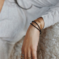 woman wearing stack of black spinel bracelets