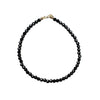 Black beaded bracelet with a 14k gold clasp on a white background