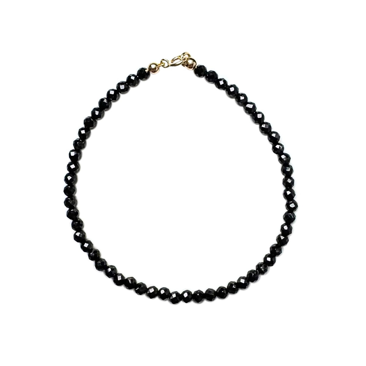 Black beaded bracelet with a 14k gold clasp on a white background