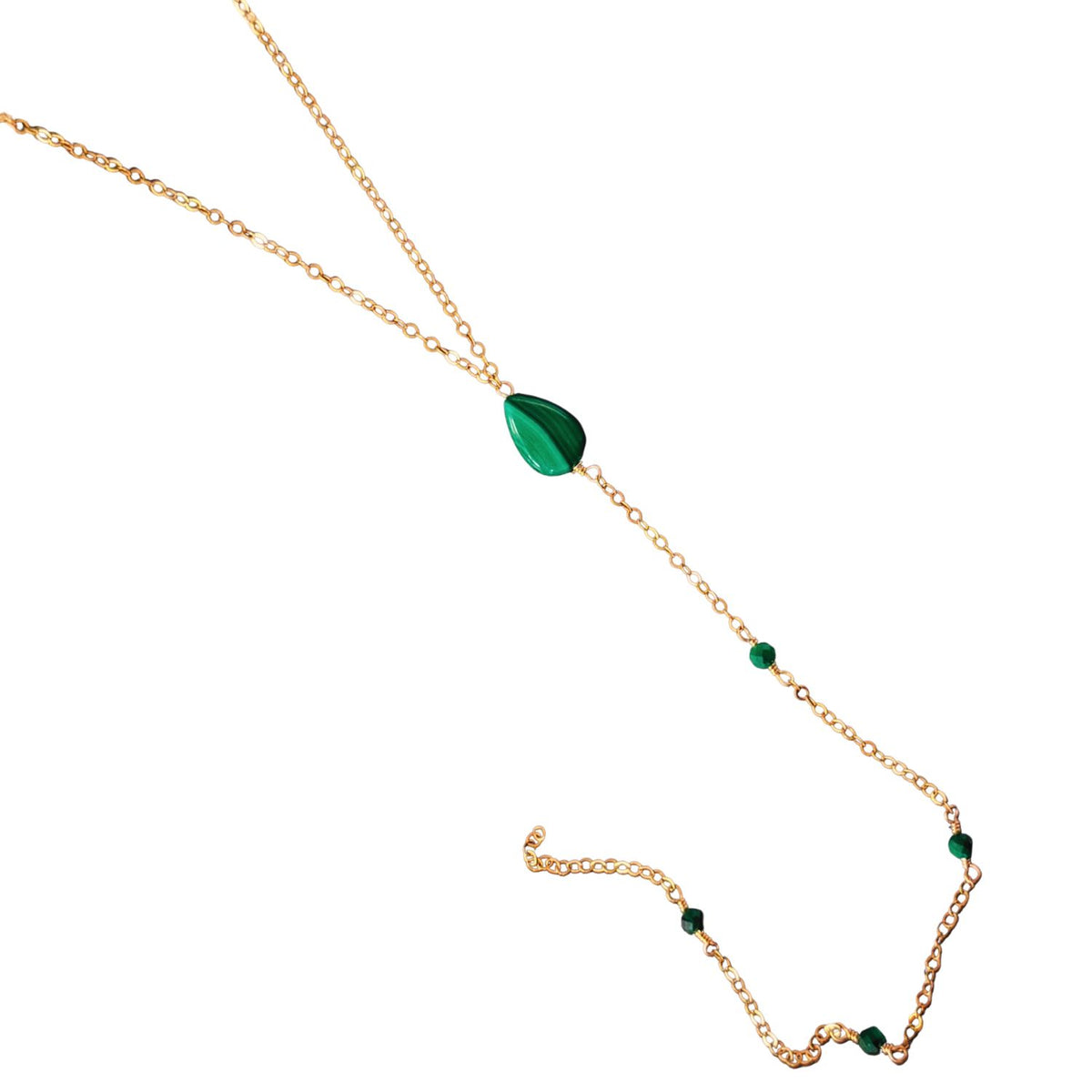 Gold necklace with green gemstones on a white background