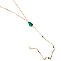 Gold necklace with green gemstones on a white background