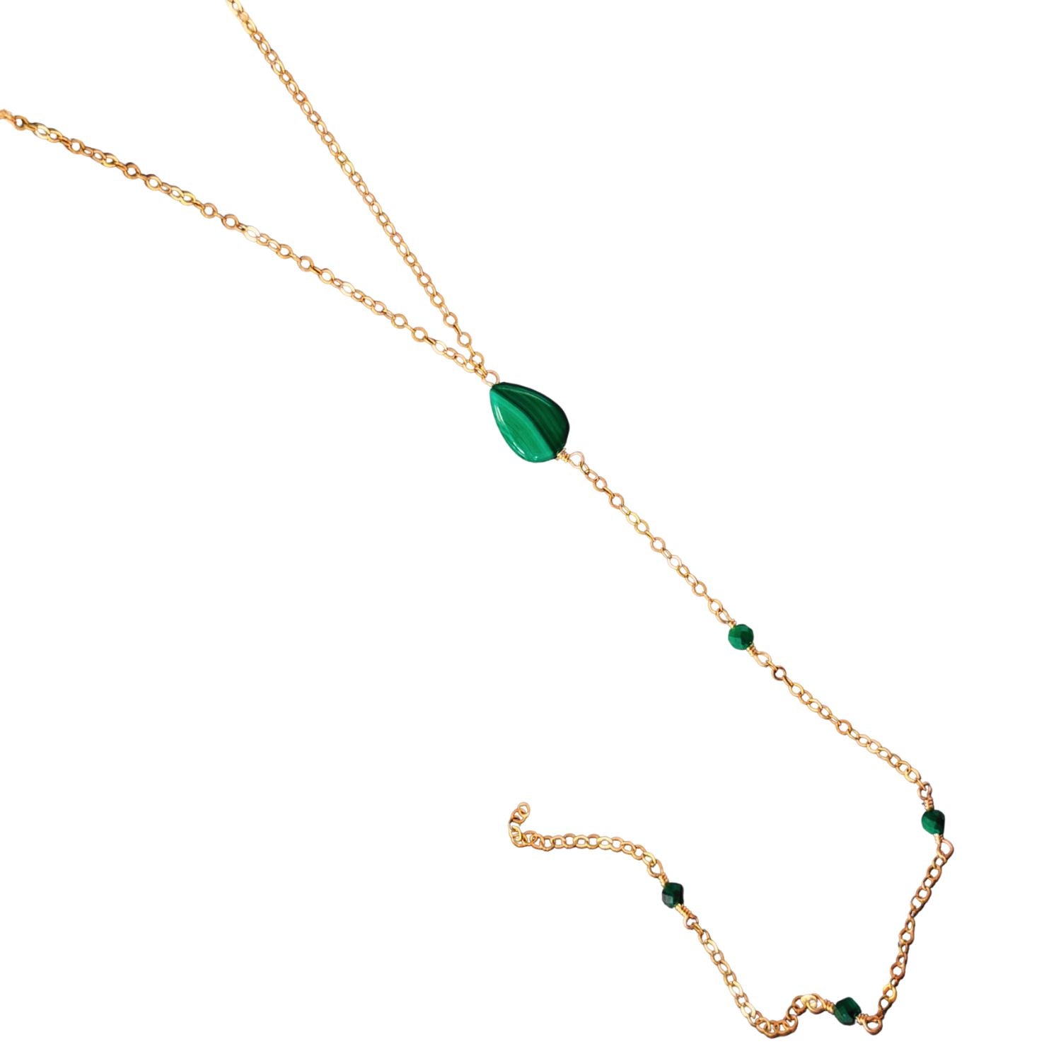 Gold necklace with green gemstones on a white background