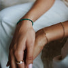 woman wearing solid gold bracelets and ring